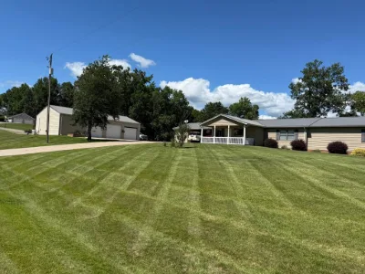 Striped lawn beside a house and garage