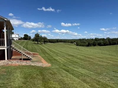 Striped hillside lawn beside a porch
